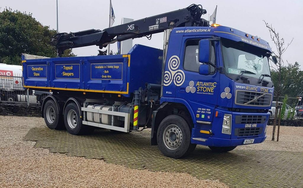 Atlantic Stone Grab lorry parked on gravel stabilising grid filled with gold quartz stone in Galway