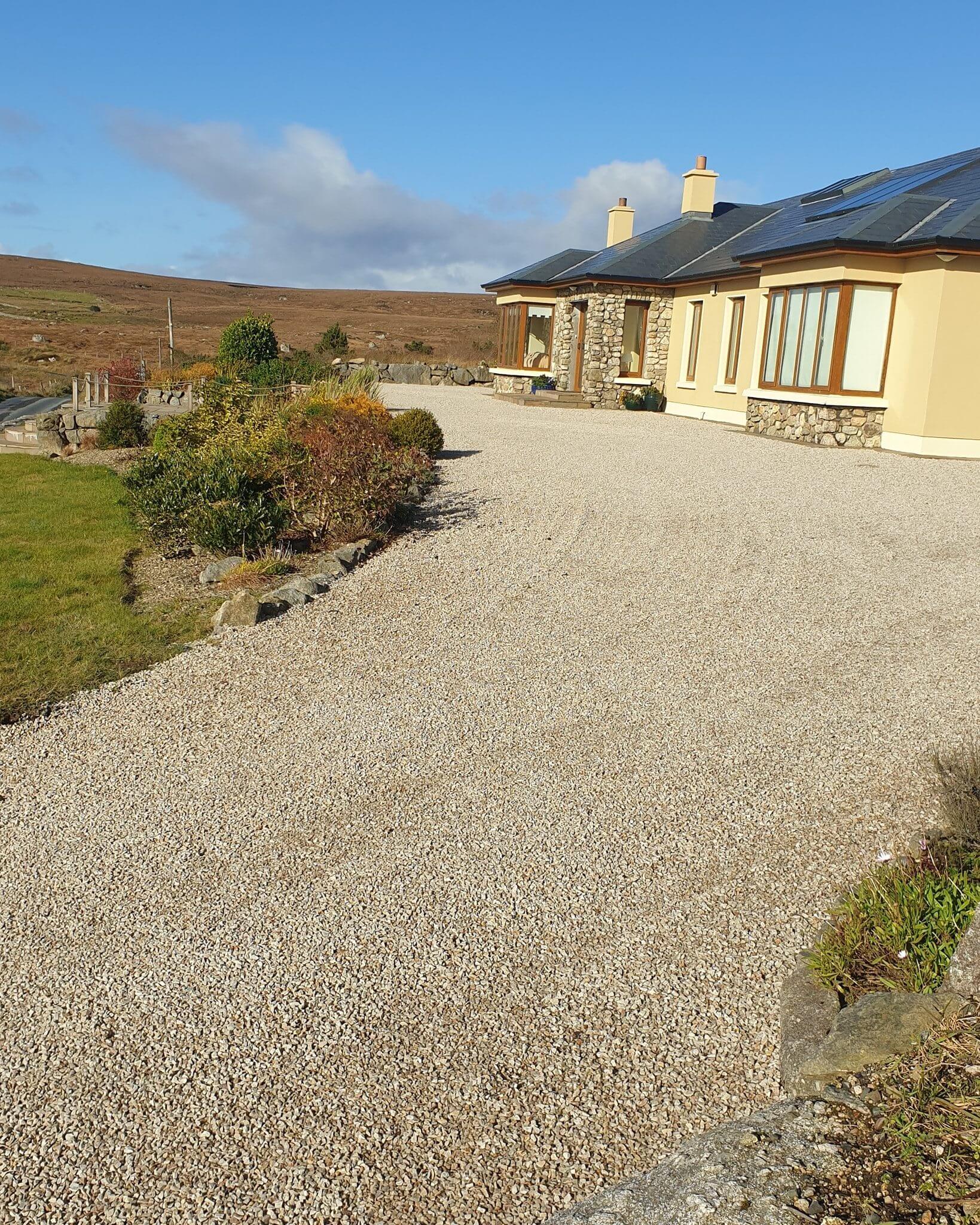 A sloping driveway with decorative quartz stone held in place with stabilisation grid in Co. Clare, Ireland.