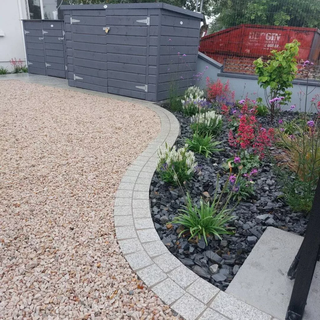 Driveway finished in 20mm gold quartz decorative stone with contrasting slate plum stone used to highlight the garden border beside it in a Dublin garden.